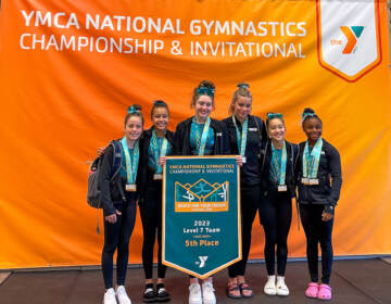 A team of gymnasts poses for a photo.