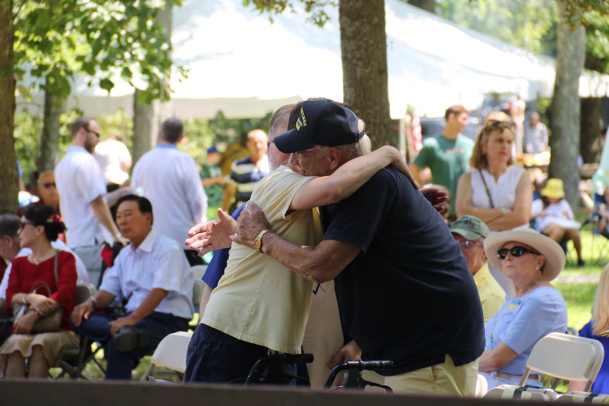 Two attendees shared a warm embrace ahead of the performances on the Ukrainian Folk Festival stage. (Cory Sharber/WHYY)