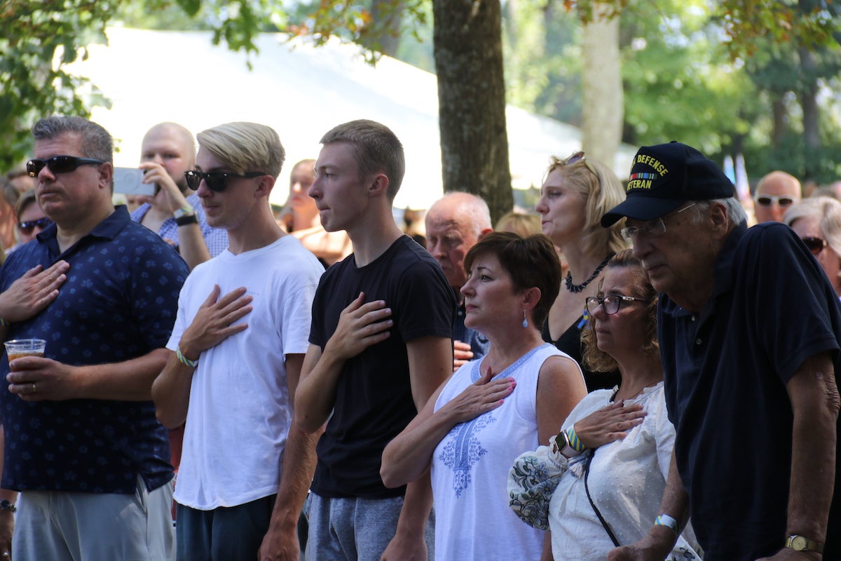 Attendees placed their hands over their hearts during a performance of ''The Star-Spangled Banner.'' (Cory Sharber/WHYY)
