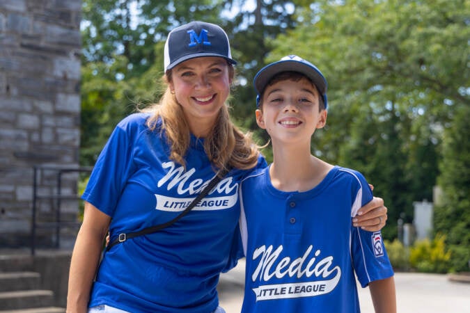 Danielle Flounders (left) and her son Joseph Flounders, 12, (right) boared the bus to Williamsport, Pa., to cheer for the 12U little league baseball team at their Little League World Series appearance on Aug. 16, 2023. (Kimberly Paynter/WHYY)