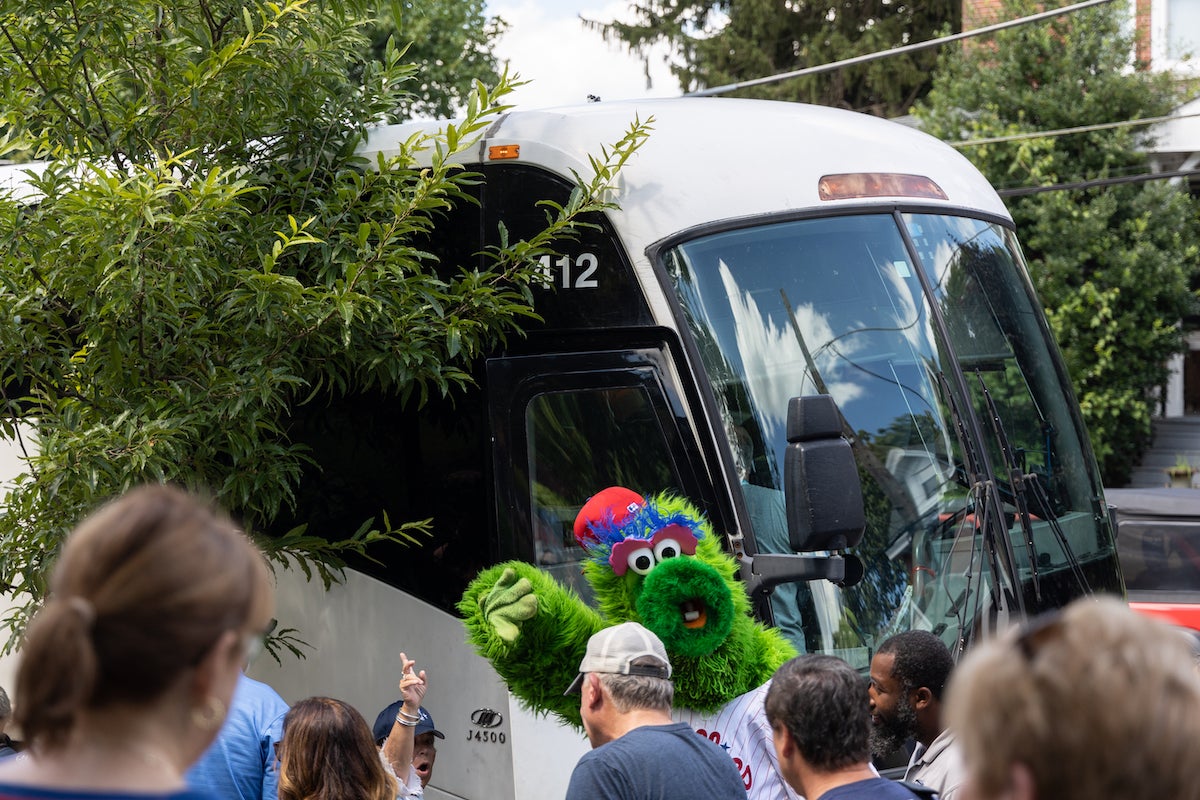 The Philadelphia Phantic offered high fives to anyone going on the bus to the Little League World Series to watch the borough’s little league team compete at a pep rally held outside the Media Borough Hall in Media, Pa., on Aug. 16, 2023. (Kimberly Paynter/WHYY)