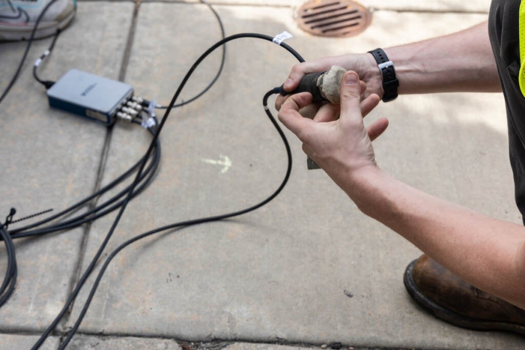 A close-up of someone holding a sensor used to record sound waves.