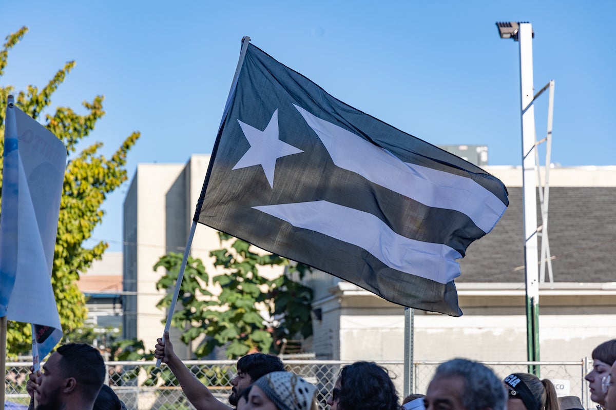 Marchers hold the black-and-white Puerto Rican resistance flag.