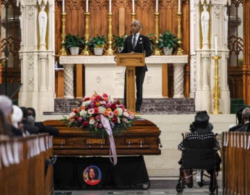 Rev. Al Sharpton at a podium behind Sheila Oliver's casket
