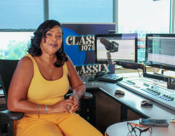 Lady B at her studio, posing next to a work station and a mic