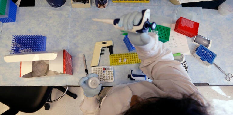 In this photo taken March 28, 2017, a research technician works to clone DNA in the immunotherapy research lab of Dr. Stanley Riddell at the Fred Hutchinson Cancer Research Center in Seattle. (AP Photo/Elaine Thompson)