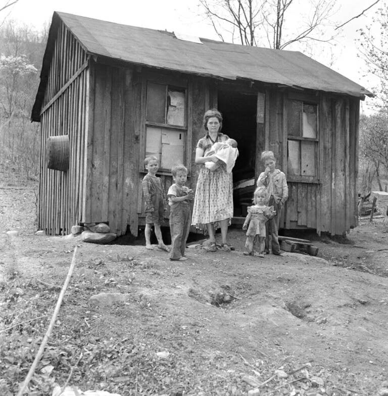 This is the home and family of Orville Sturgill, a United Mine Worker who is out of work due a strike in this coal field for higher wages in Mayking, Kentucky on April 28, 1959. Sturgill, with another miner, work a small truck mine but cannot market their production. This one room shack is on a county road running along Cram Creek. The five children, left to right are: Anderson, 6, Orville Ray, 5, Mrs. Cornia Mae Sturgill holds John, one month, Pricilla Ann, 2, and Arnold 8. Sturgill has a little garden patch in back of the house which he and the oldest son work. A sixth child is in Blind school in Louisville. (AP Photo/HBL)