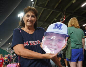 Marine Dempsey holds a cutout of grandson Trevor Skowronek's face at the Little League World Series