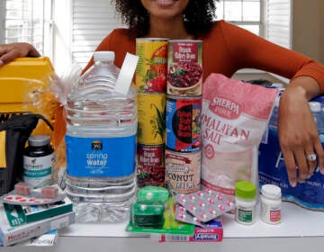 In this Friday, Sept. 29, 2017, photo, Lexi Montgomery poses with supplies she has purchased in the event of another storm, in Miami Beach, Fla. Hurricane Irma was the first hurricane that Montgomery ever experienced.