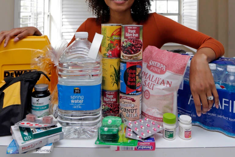 In this Friday, Sept. 29, 2017, photo, Lexi Montgomery poses with supplies she has purchased in the event of another storm, in Miami Beach, Fla. Hurricane Irma was the first hurricane that Montgomery ever experienced.