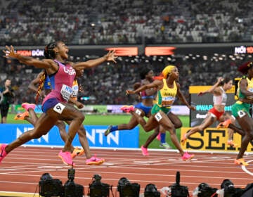 Sha'Carri Richardson, of the United States, spreads her arms as she crosses the line to win the women's 100-meter final during the World Athletics Championships in Budapest, Hungary.