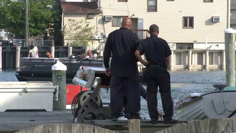 Officers standing on a dock looking down at a boat