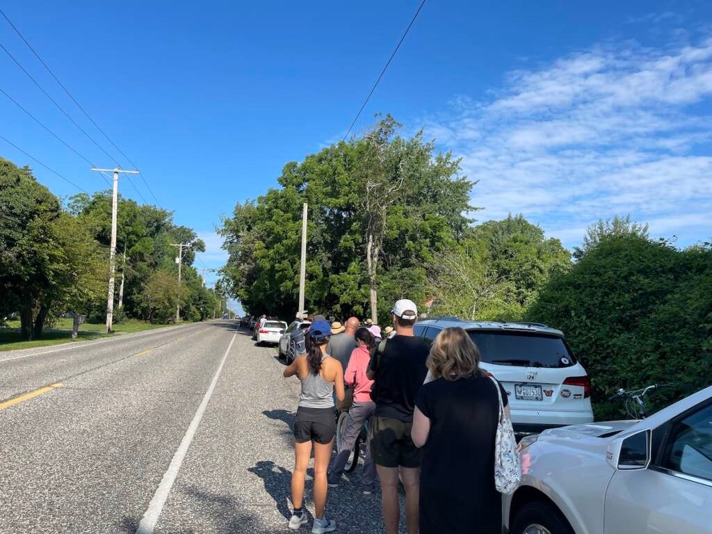 Customers wait on the side of the road.