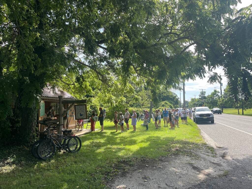 Customers wait in line outside of the stand.