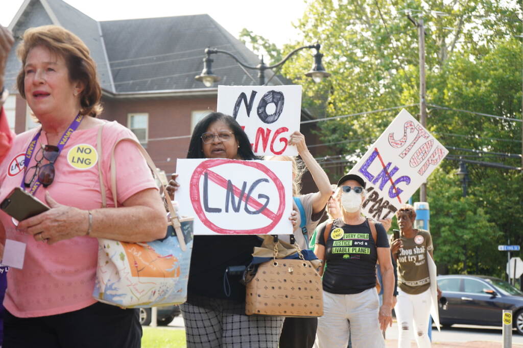People hold protest signs read NO LNG and more.