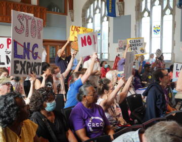 People raise their hands and signs