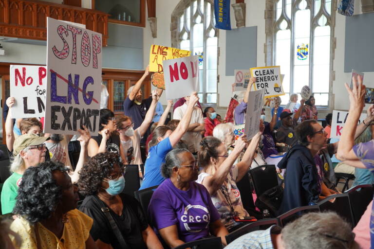 People raise their hands and signs