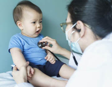 Doctor using a stethoscope on an infant.