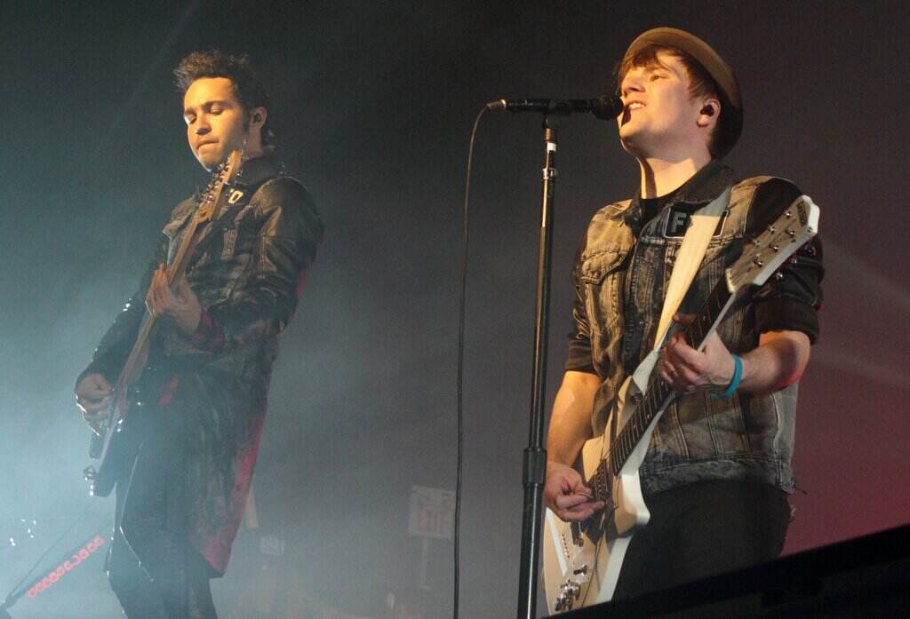 Members of Fall Out Boy play onstage.