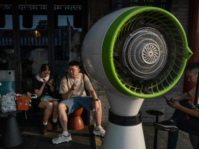 2 people sitting outside in the heat