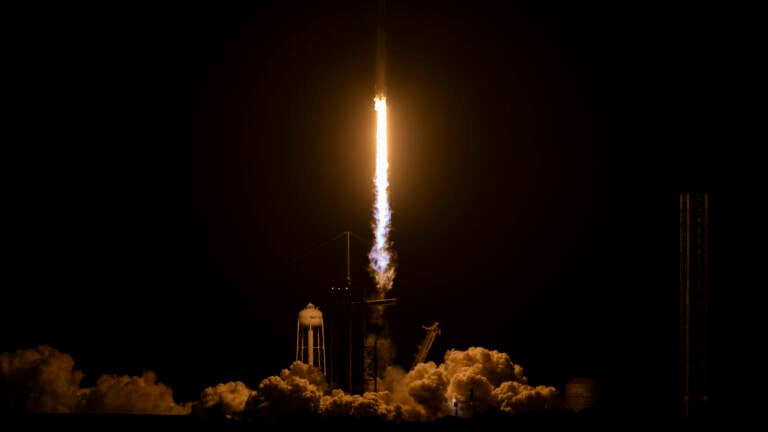 A SpaceX Falcon 9 rocket lifts off in the dark.