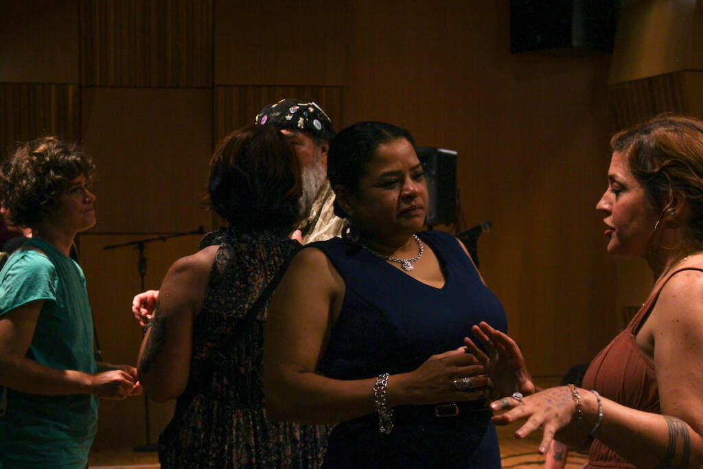 Roz Pichardo (center) listens to Jacqueline Jugan speak