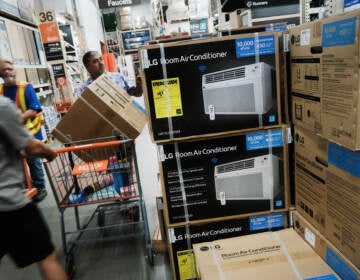 People shop for air conditioners during a heat wave last week in New York City. Many people who live in public housing can't afford such units or the utility bills that come with them — and there's no federal requirement for air conditioning.