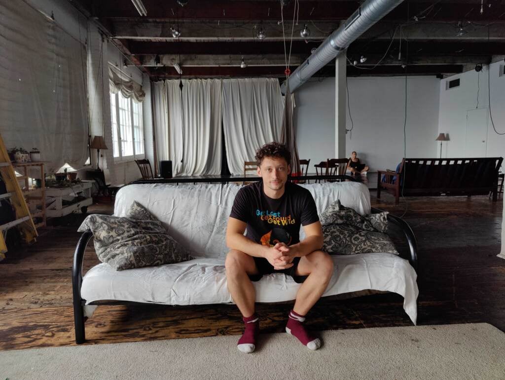 Ben Grinberg sits on a couch, posing for a photo.