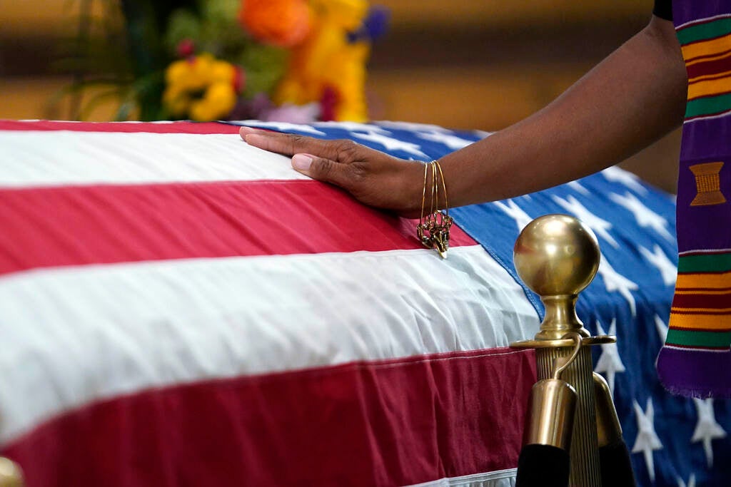 A mourner touches the flag-draped casket of Lt. Gov. Sheila Oliver as she lies in state in the rotunda of the New Jersey State House on Thursday, Aug. 10, 2023, in Trenton.