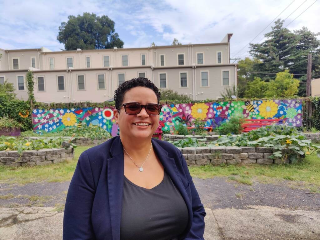 Michelle Carrera posing for a photo in the community garden.