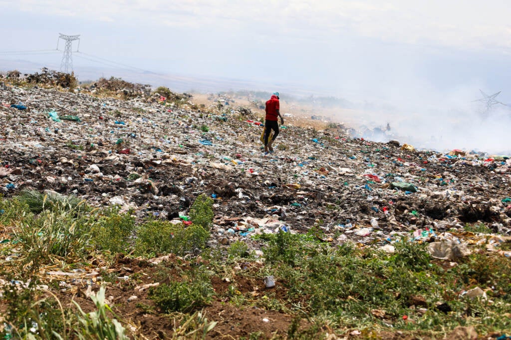 At Dadach Boshe dump, 23-year-old waste vendor Suleiman Galgalo picks among the plastic bags to find bottles and scrap metal he can sell.