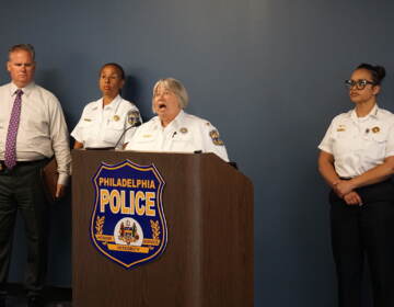 Christine Coulter speaking at a podium with other police officials
