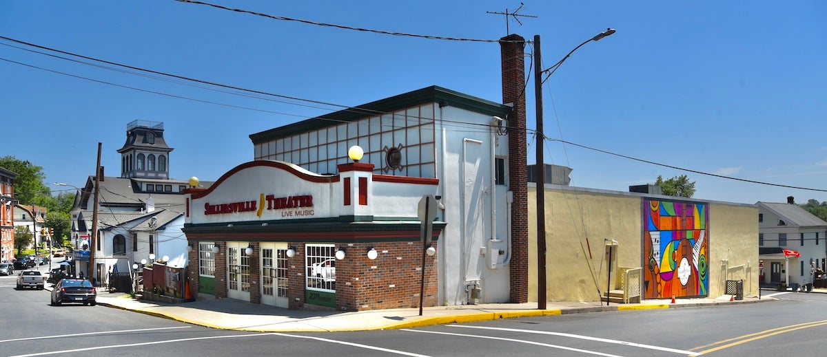 The Sellersville Theater is seen from across the street. A mural is visible on its side.