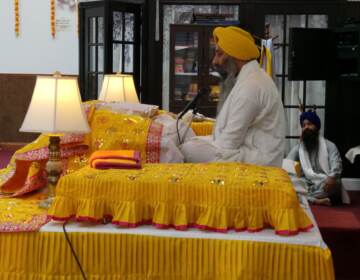 Head Priest Giani Gurjit Singh recites hymns from the Sikh Holy Scripture as members of sangat (community) listen.