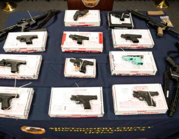 Allegedly straw purchased weapons are laid out on a table.