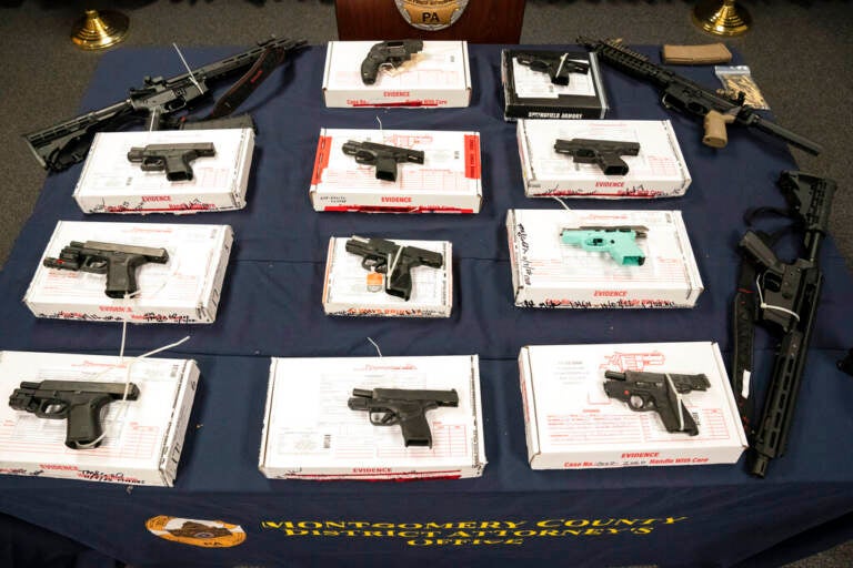 Allegedly straw purchased weapons are laid out on a table.