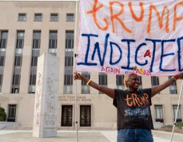 Nadine Seiler holds up a sign that says, ''Trump indicted again and again'' outside federal court