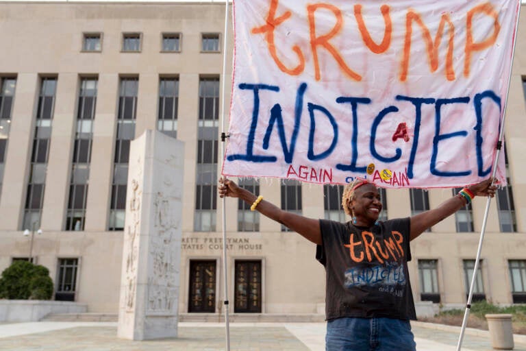 Nadine Seiler holds up a sign that says, ''Trump indicted again and again'' outside federal court