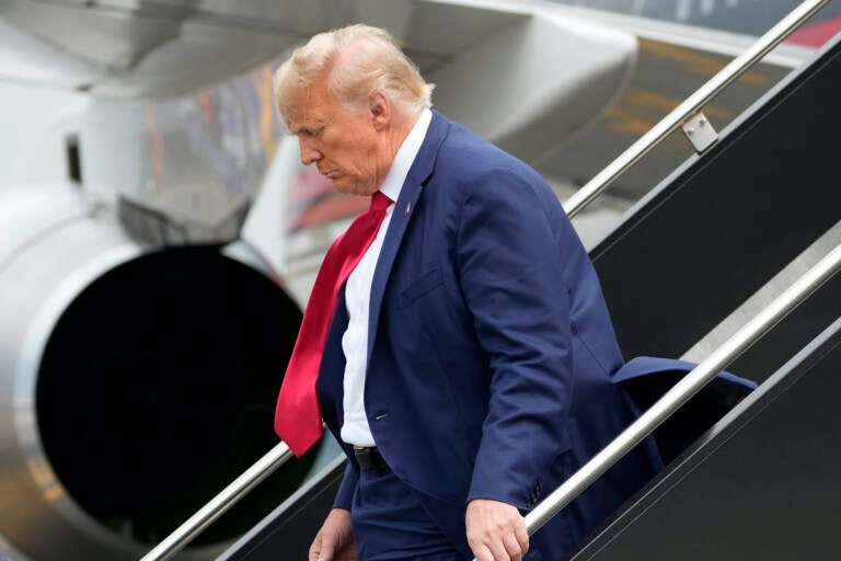 Donald Trump stepping off of an airplane.