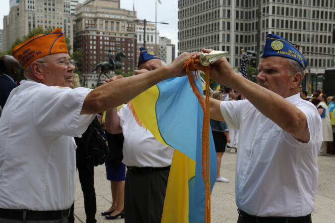 Ukrainian American veterans worked to properly fold a flag following the flag raising at City Hall