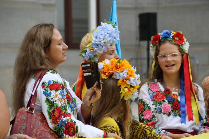 People dressed in flowered clothing stand together.