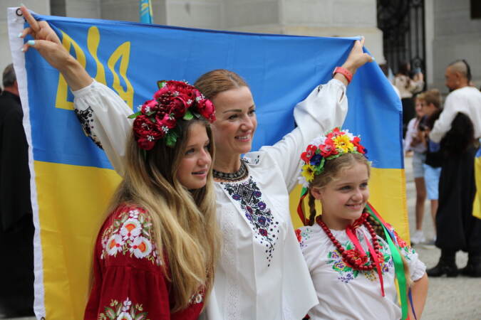 Children and adult pose with a Ukrainian flag