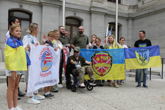 Ukrainian veterans gathered with their loved ones for photos following the flag raising ceremony on Thursday. (Cory Sharber/WHYY)