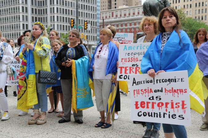 People hold signs that read: America, recognize Russia and Belarus as terrorist countries