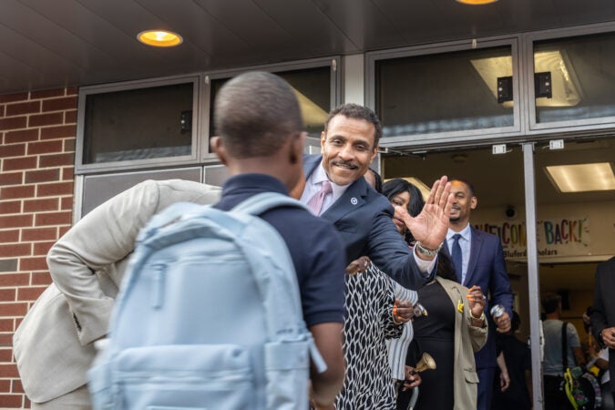 Tony Watlington giving kids high-fives as they walk into school