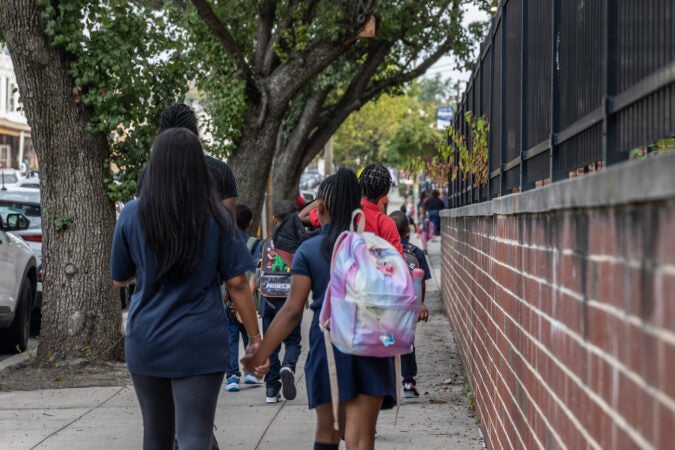 Parents walking their children to school