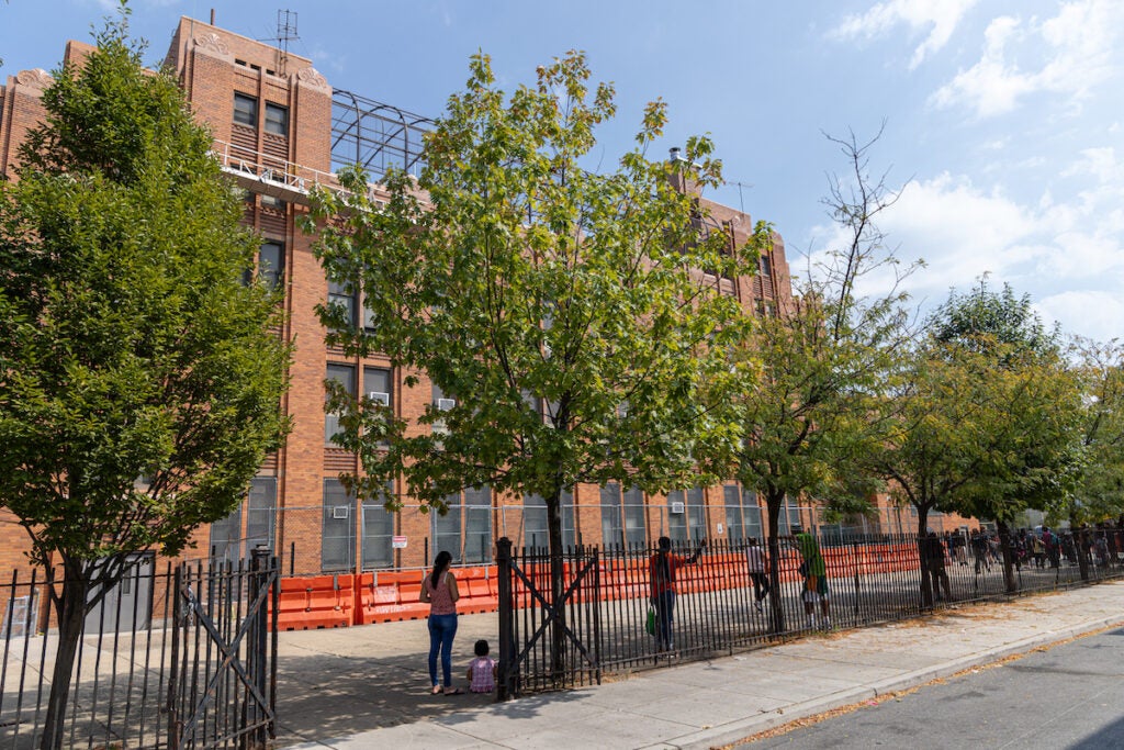 Parents wait for kids in the shade outside of the Spring Garden School.