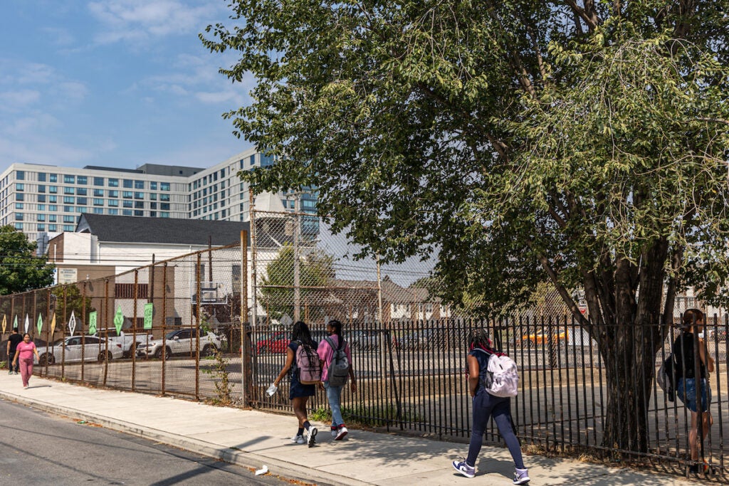 Students walk along a sidewalk.