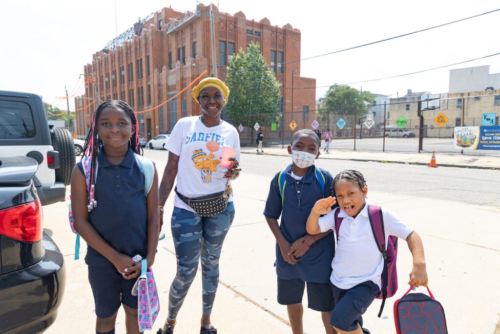 Leetonia Walton met her kids Azariah (left), Tyrone (second from right) and their friend Mason (right) pose for a photo outside of the Spring Garden School.