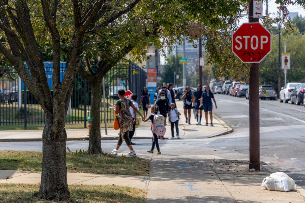 Parents and students walk down the sidewalk after an early dismissal.